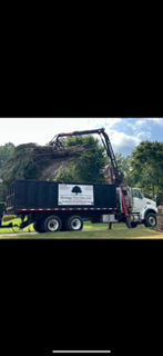 Heritage grapple truck loading branches and tree debris